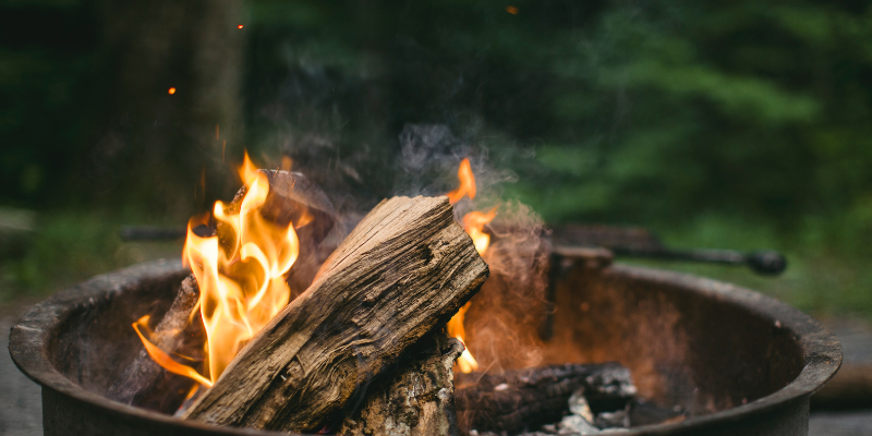 Wooden firepit against green background.